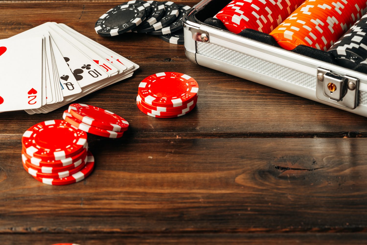 Jetons de poker et cartes disposés sur une table de club pour illustrer le budget nécessaire à un joueur débutant.